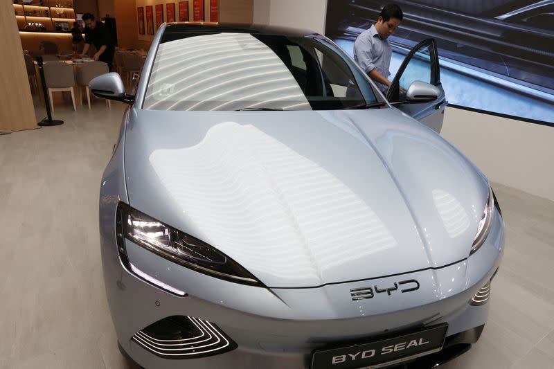 A BYD Seal is displayed next to dining area at a BYD By 1826 cafe and car dealership in Singapore