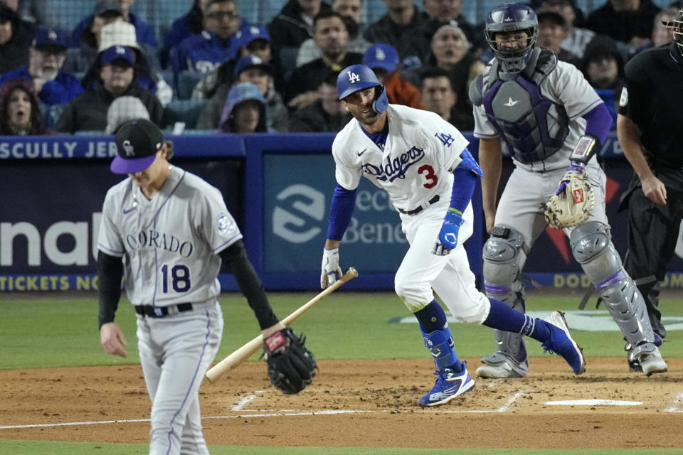 Los Angeles Dodgers' Chris Taylor, center, runs to first after hitting a two-run home run as Colorado Rockies starting pitcher Ryan Feltner, left, stands on the mound and catcher Elias Diaz watches during the third inning of a baseball game Monday, April 3, 2023, in Los Angeles. (AP Photo/Mark J. Terrill)