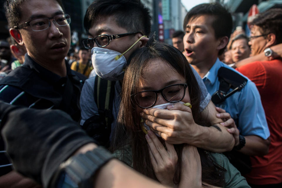 Pro-democracy activists are pushed through the crowd to safety after clashing with local residents and pro-government supporters on October 3, 2014 in Mong Kok, Hong Kong. (Photo by Chris McGrath/Getty Images)