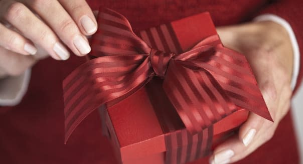 Woman Adjusting Bow on Gift