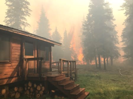 Firefighters from the Chugach National Forest work to protect the Romig Cabin on Juneau Lake from the Swan Lake Fire near Cooper Landing
