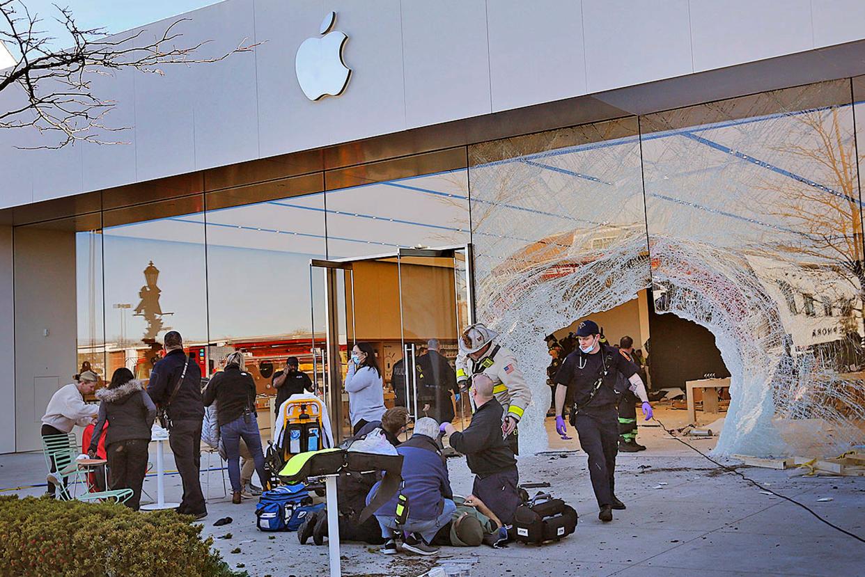 Emergency workers aid injured shoppers after an SUV drove into an Apple store, Monday, Nov. 21, 2022, in Hingham, Mass. Several people were injured in the incident, according to authorities.