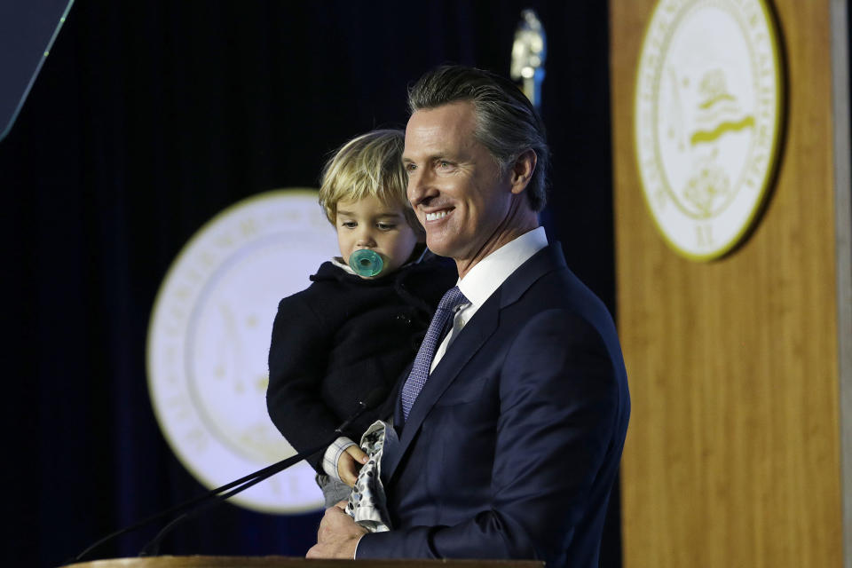 California Governor Gavin Newsom holds his son, Dutch, while speaking during his inauguration Monday, Jan. 7, 2019, in Sacramento, Calif. (AP Photo/Rich Pedroncelli)