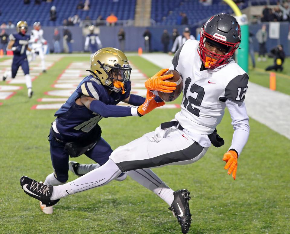 Toledo Central Catholic wide receiver Durye'a Hall catches a first-half TD pass over Hoban defensive back Tylan Boykin in the OHSAA Division II state final at Tom Benson Hall of Fame Stadium, Thursday, Dec. 1, 2022, in Canton.