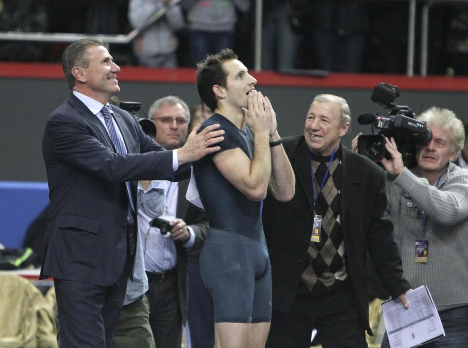 France's Renaud Lavillenie, center, celebrates after setting a new world indoor record of 6.16 meters while legendary Sergey Bubka, left, congratulates the winner at the "Pole Vault Stars" event at Donetsk in eastern Ukraine, Saturday, Feb. 15, 2014. Lavillenie broke Sergei Bubka's 21-year-old indoor pole vault world record. (AP Photo)