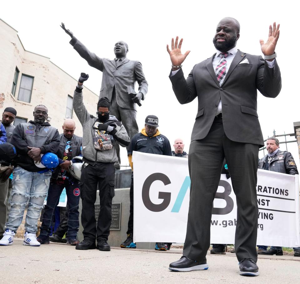 The Rev. Doyle Sprewer says a prayer at the foot of the Martin Luther King Jr. statue before the Youth Victory Over Violence Walk down North King Drive in Milwaukee on Sunday.