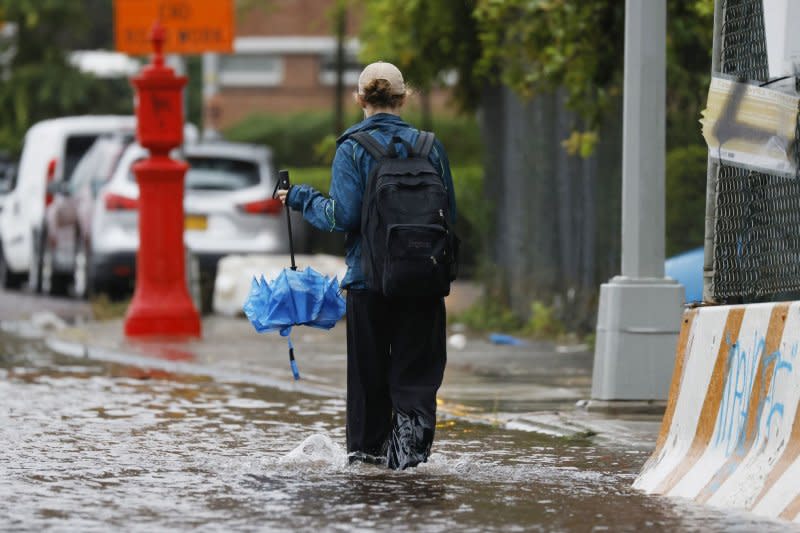 A pedestrian walks through a flooded area along FDR Drive in lower Manhattan during a rain storm in New York City on Friday. New York City is in a state of emergency as torrential rain floods subways, roads and basements. Photo by John Angelillo/UPI