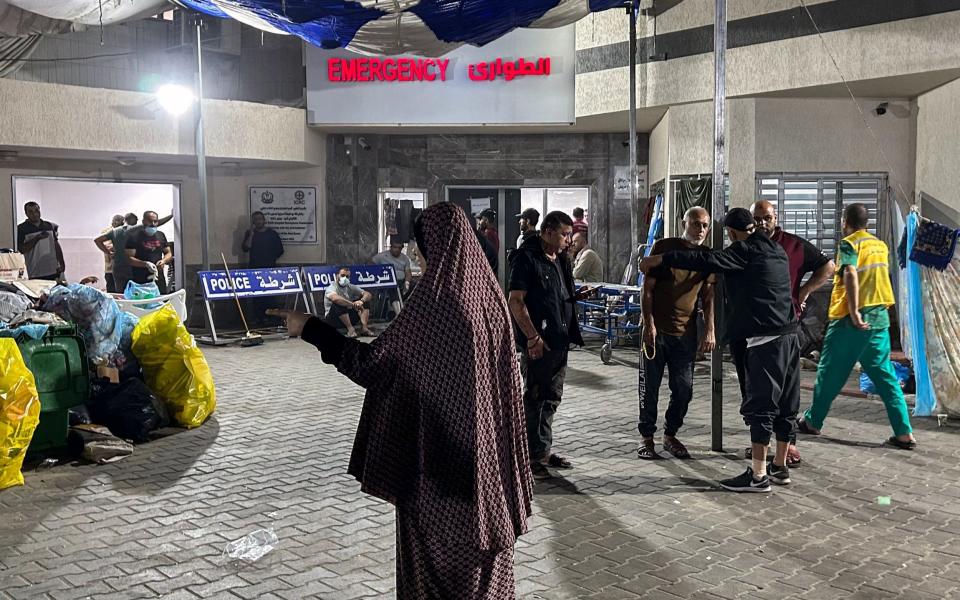 People stand outside the emergency ward of Al-Shifa hospital in Gaza City