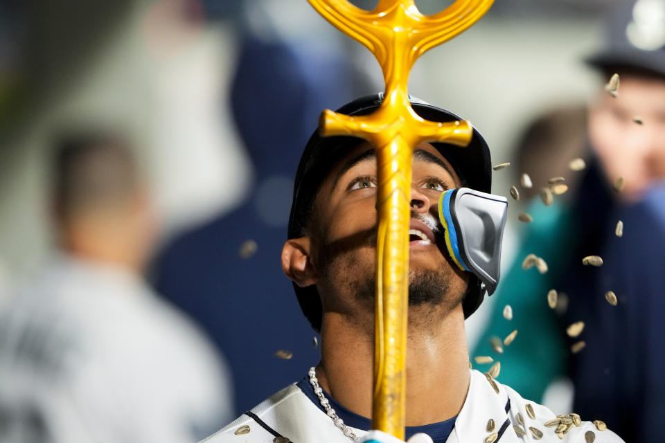 Seattle Mariners' Julio Rodríguez holds a trident in the dugout as he celebrates hitting a solo home run against the Texas Rangers during the fourth inning of a baseball game Thursday, Sept. 28, 2023, in Seattle. (AP Photo/Lindsey Wasson)