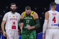 Lithuania center Jonas Valanciunas (17) celebrates a basket between Montenegro centers Bojan Dubljevic (14) and Nikola Vucevic (4) during the second half of a Basketball World Cup group D match in Manila, Philippines Tuesday, Aug. 29, 2023.(AP Photo/Michael Conroy)