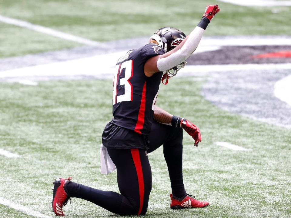 Mykal Walker of the Atlanta Falcons kneeling during a game.