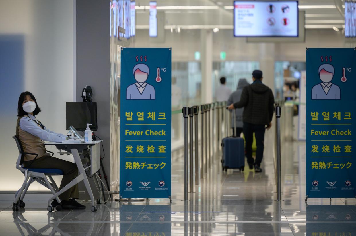 A health worker waits to screen passengers at Incheon international Airport in South Korea.