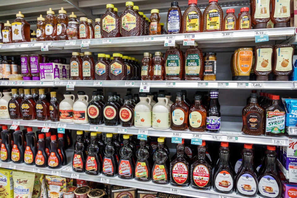 Bottles of maple syrup on a shelf.