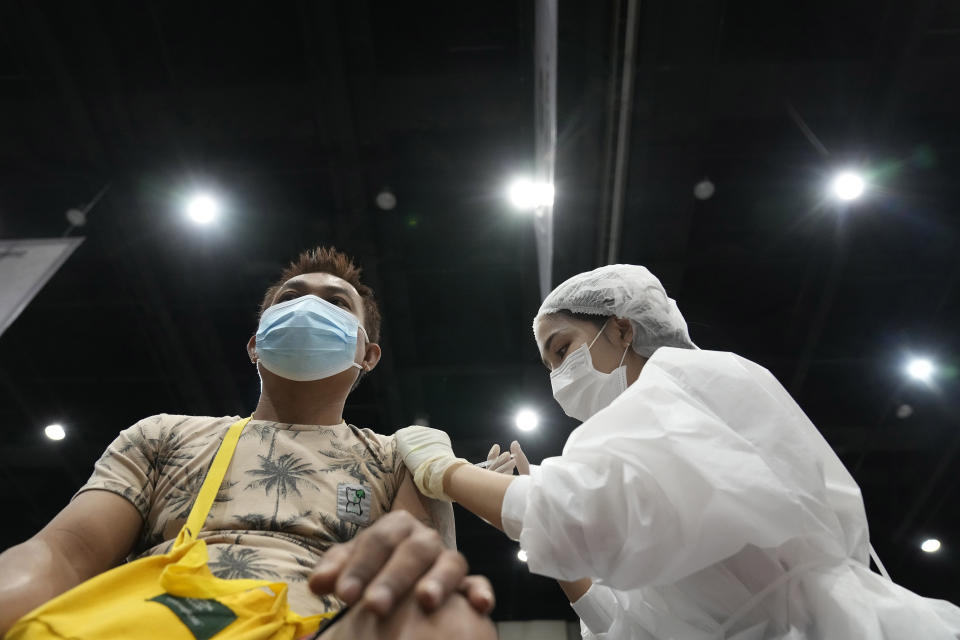 A health worker administers a dose of the AstraZeneca COVID-19 vaccine to a man in Bangkok, Thailand, Friday, Aug. 20, 2021. Thailand has recorded more than 1 million accumulated cases on Friday since the pandemic started in 2020. (AP Photo/Sakchai Lalit)