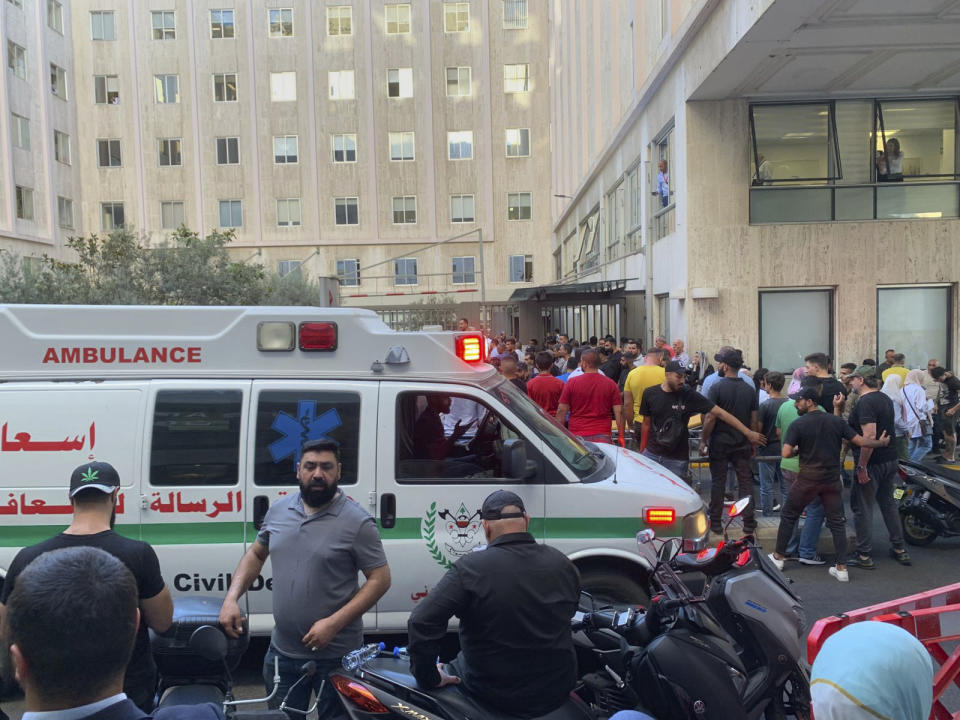 People gather outside the American University hospital after the arrival of several men who were wounded by exploded handheld pagers, in Beirut, Lebanon, Tuesday, Sept. 17, 2024. (AP Photo/Bassam Masri)