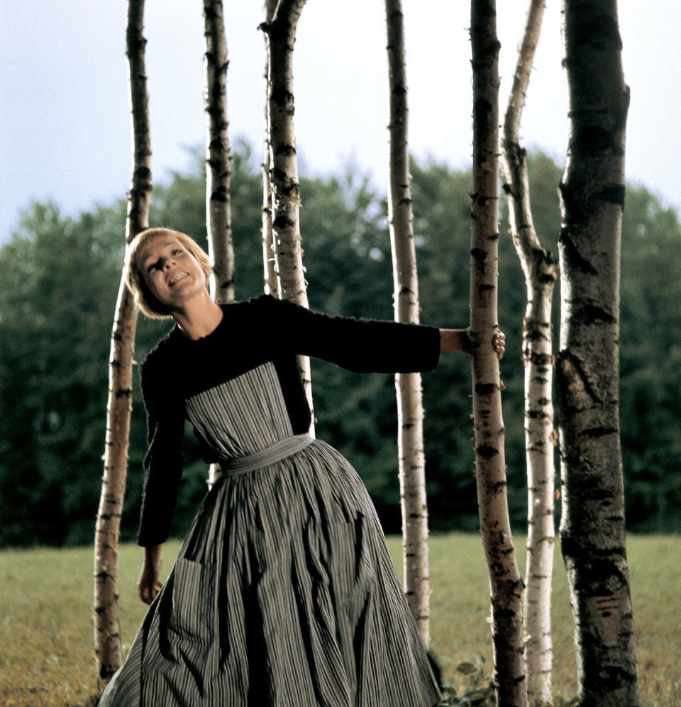 A woman singing on a mountain top between trees