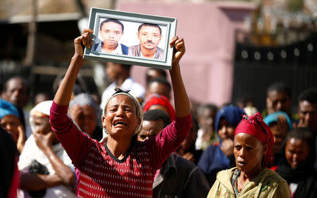 A woman carries a photograph as she mourns her family members suspected to be missing following a landslide when a mound of trash collapsed on an informal settlement at the Koshe garbage dump in Ethiopia's capital Addis Ababa, March 14, 2017. REUTERS/Tiksa Negeri