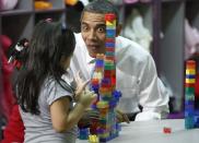 El presidente Barack Obama reacciona mientras una niña juega con bloques de Lego, durante su visita a un aula del Yeadon Regional Head Start Center en Yeadon, Pensilvania, 8 de noviembre, 2011. (AP Photo/Charles Dharapak)