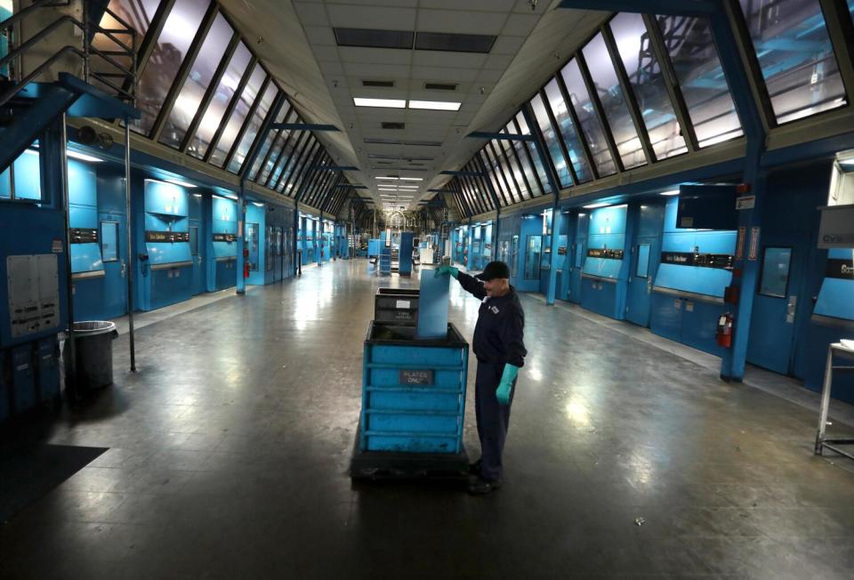 Pressman Sam Pulido deposits plates in a bin inside the pressroom.