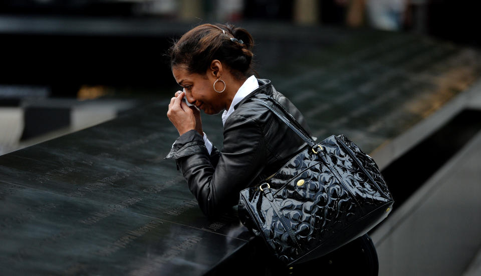 NEW YORK, NY - SEPTEMBER 11: A woman who did not wish to be identified pauses at the edge of the North Pool during memorial observances held at the site of the World Trade Center on September 11, 2014 in New York City. This year marks the 13th anniversary of the September 11th terrorist attacks that killed nearly 3,000 people at the World Trade Center, Pentagon and on Flight 93.  (Photo by Justin Lane- Pool/Getty Images)
