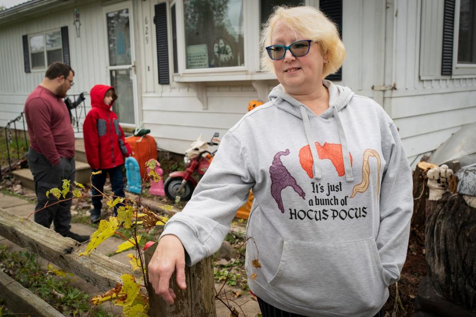 Annette Kramer, 54, stands in her Corunna front yard on Monday, Oct. 16, 2023 with her partner William Petrusha, 35, back left, and her grandson Kire Dumont, 10, who she is guardian of. Kramer has been on strike at GM in Lansing since Sept. 22,