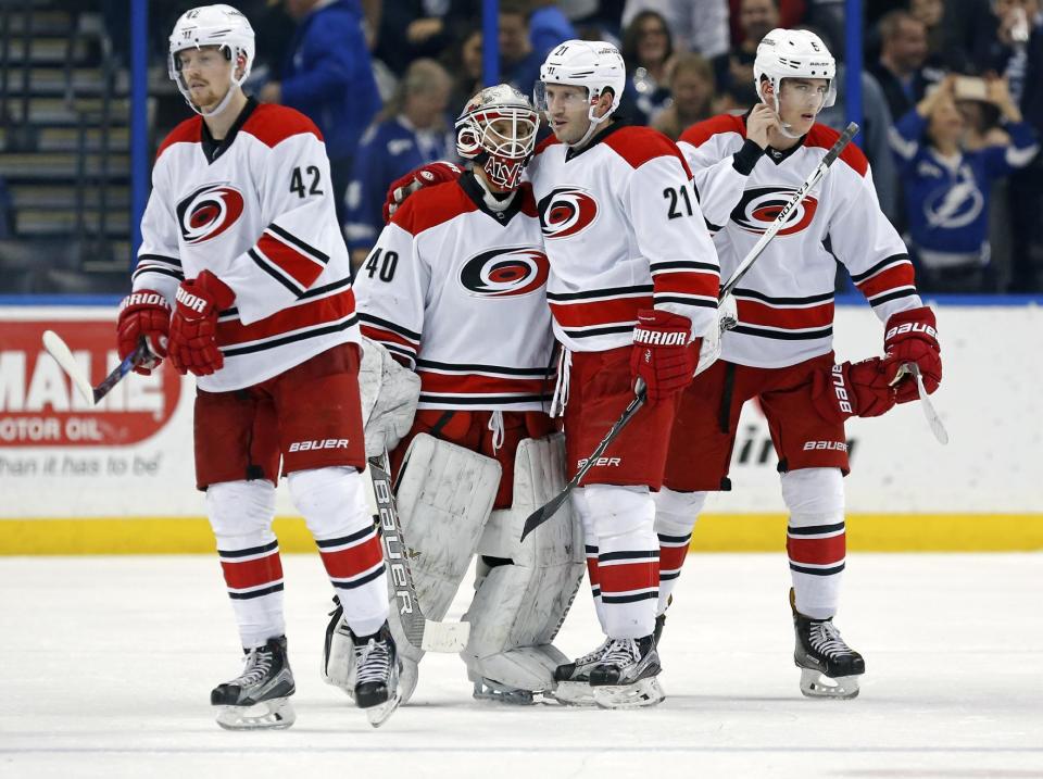 Carolina Hurricanes emergency backup goalie Jorge Alves (40) is congratulated by Joakim Nordstrom (42), of Sweden, Lee Stempniak (21), and Noah Hanifin (5) following his NHL debut in an NHL hockey game against the Tampa Bay Lightning on Saturday, Dec. 31, 2016, in Tampa, Fla. The Lightning won 3-1. (AP Photo/Mike Carlson)