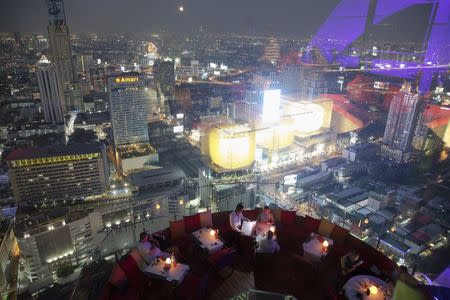 Visitors and tourists enjoy drinks and the view from a rooftop bar in central Bangkok April 1, 2015. REUTERS/Damir Sagolj