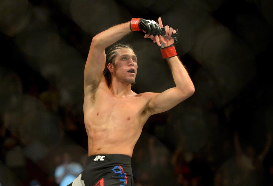 Brian Ortega climbs the cage after winning his featherweight bout at UFC 199 on June 4, 2016. (Getty)