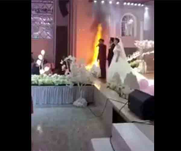 Novios no se inmutan ante incendio de su boda. Foto: youtube/BTMG