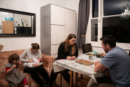 Adi, 37, who works for a removal company, and his sister Nicoleta, 34, play a game of 'moara', which they used to play when they were younger, while Maria and the children sit nearby at Maria's brothers house where there is more space, in London, Britain, February 19, 2019. REUTERS/Alecsandra Dragoi