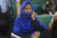 In this Wednesday, April 1, 2020, photo, Golforaj Begum, a 54-year-old Rohingya refugee, sits at the Kutupalong refugee camp, Cox’s Bazar, Bangladesh. "The organizations working here told us about cough, cold and soar throat being the symptoms of the coronavirus," "They also told us how to maintain our safety. Such as not to go to other rooms, maintaining a 5-foot distance from one another, not to mix in a crowd, washing hands properly before cooking and eating. They also told us to keep our backyards clean," she said. Aid workers are bracing for a possible outbreak of the coronavirus in one of the world's largest refugee camps in Bangladesh, but officials are already warning that containing the disease among more than 1 million tightly packed Rohingya Muslims will be a daunting task. (AP Photo/Suzauddin Rubel)