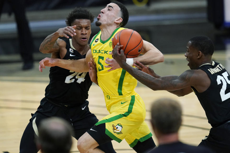 Colorado guard McKinley Wright IV, right, steals the ball from Oregon guard Chris Duarte, center, who drives the lane past Colorado guard Eli Parquet in the second half of an NCAA college basketball game Thursday, Jan. 7, 2021, in Boulder, Colo. (AP Photo/David Zalubowski)