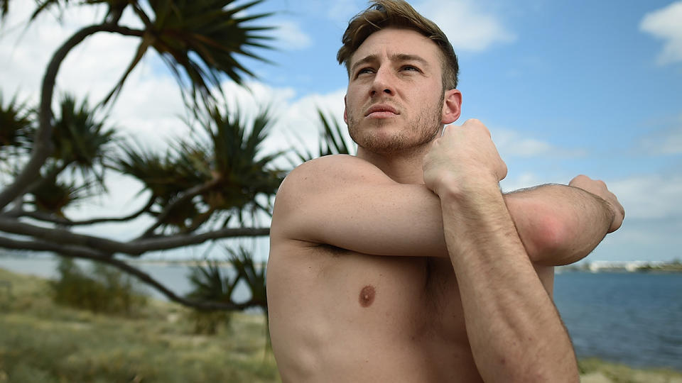 Matthew Mitcham is pictured stretching his arms.