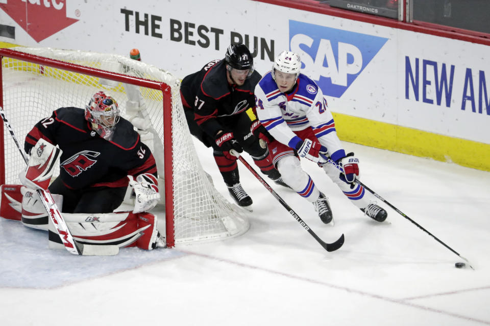 New York Rangers right wing Kaapo Kakko (24) drives against Carolina Hurricanes goaltender Antti Raanta (32) and right wing Andrei Svechnikov (37) during the first period in Game 2 of an NHL hockey Stanley Cup second-round playoff series Friday, May 20, 2022, in Raleigh, N.C. (AP Photo/Chris Seward)