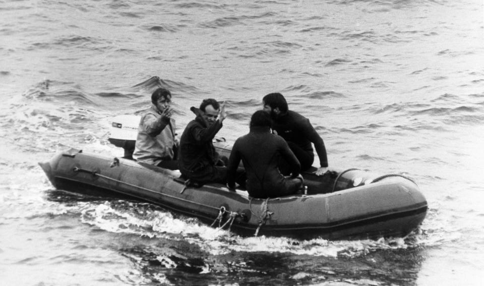 Roger Chapman (second left) waves as he is taken to the <em>Vickers Voyager</em> after being released from the <em>Pisces III</em>. <em>Photo by PA Images via Getty Images</em>