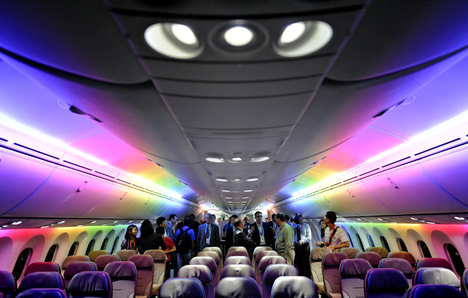 FILE - In this Feb. 12, 2012, file photo, members of the media tour Boeing 787 Dreamliner's cabin displaying versatile LED lighting system during a press preview in Singapore. While Boeing’s 787 Dreamliners are grounded, the batteries causing airliner’s troubles can still fly. At the time the government certified the 787 as safe, federal rules barred the type of batteries used to power the airliner’s electrical systems from being carried as cargo on passenger planes because of the fire risk. But new rules exempt aircraft batteries from the ban on large lithium ion batteries as cargo on flights by passenger planes. (AP Photo/Bryan van der Beek, File)