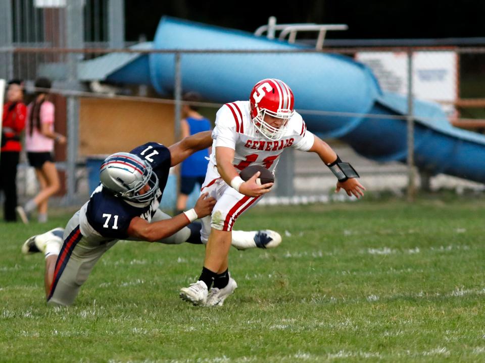 Morgan's Wade Pauley tries to sack Sheridan quarterback Caden Sheridan during the first half on Friday night in McConnelsville. Sheridan won, 18-13, to improve to 3-1.