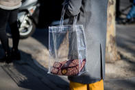 <p>Model carries her Dior bag and wallet in a clear plastic tote. (Photo: Getty Images) </p>