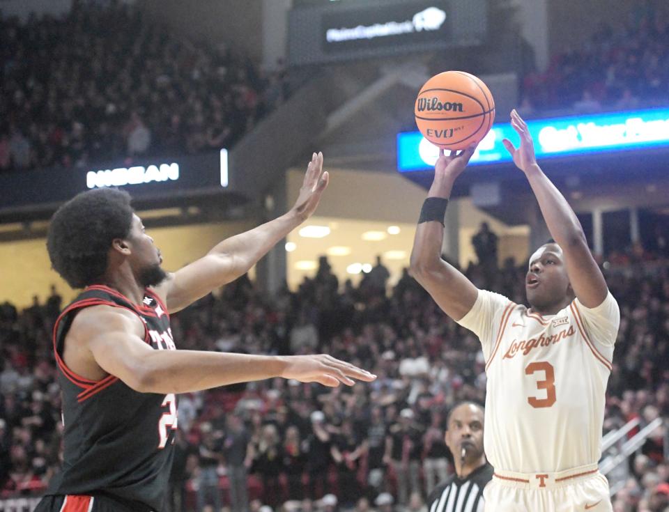 Texas guard Max Abmas, right, shoots the ball against Texas Tech in Tuesday's Big 12 game in Lubbock. Abmas broke out of a scoring slump with 18 points while helping Texas to an emotional 81-69 win.