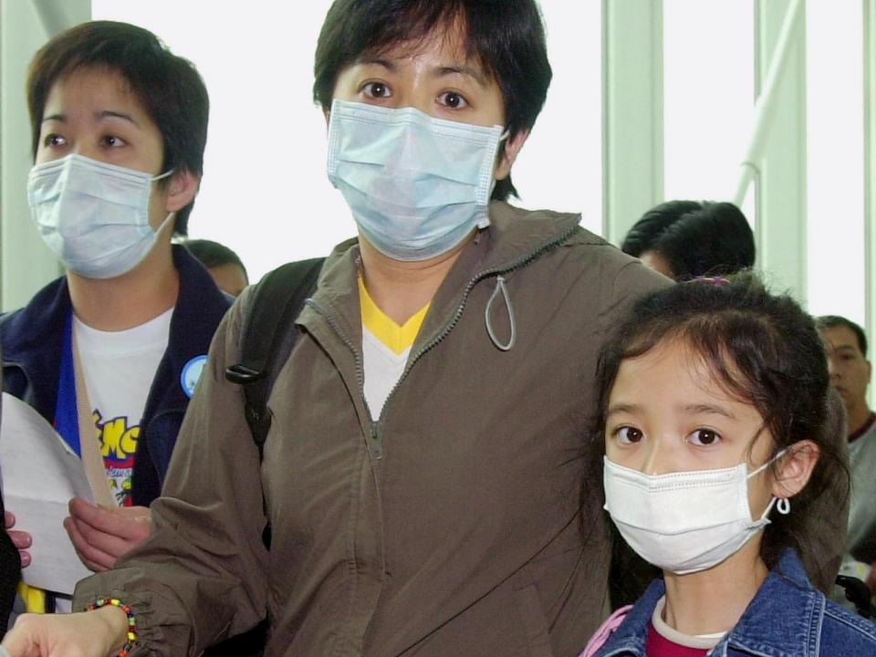 Passengers wearing masks, walk out from a flight from Hong Kong at the Incheon International Airport, 50km (30 miles) west of Seoul, South Korea, Friday, April 4, 2003.