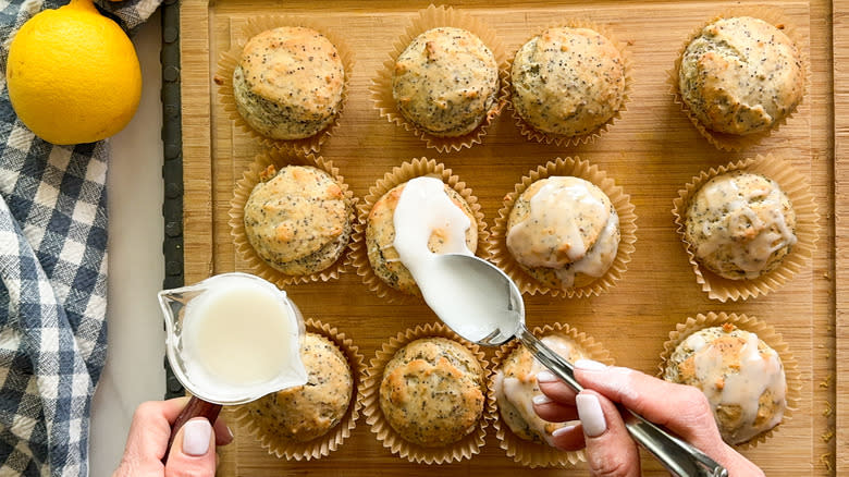 hand adding icing to lemon poppy seed muffins