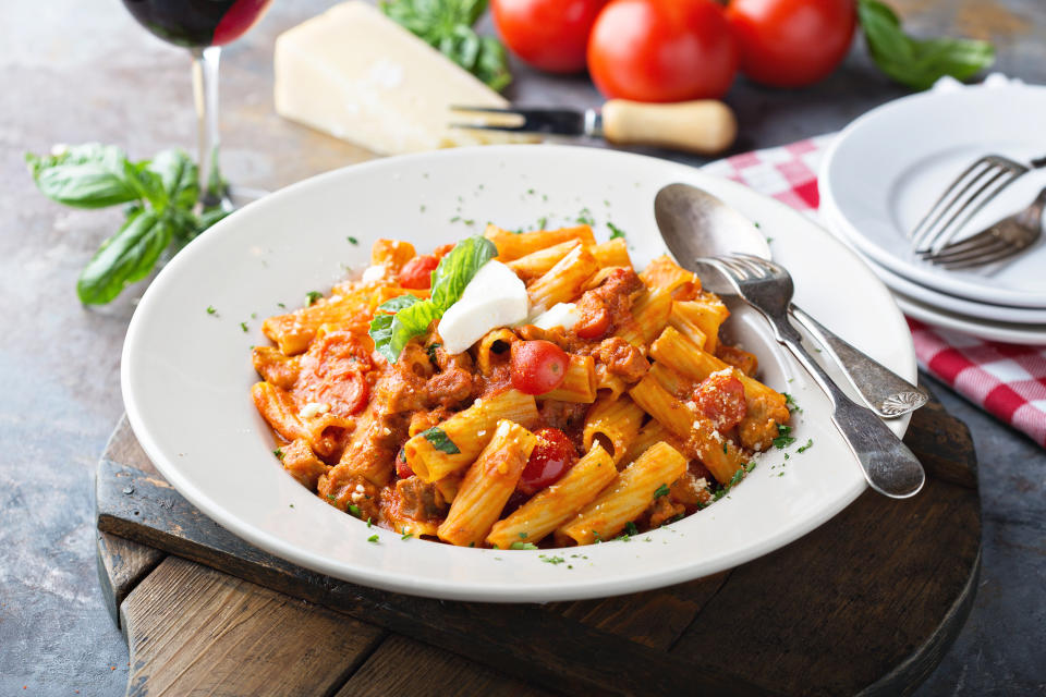 Rigatoni bolognese with fresh mozzarella and basil in a big plate. (Photo: Getty Images)