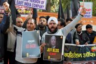 Members of the Confederation of All India Traders hold placards and shout slogans during a protest against the visit of Jeff Bezos to India, in New Delhi