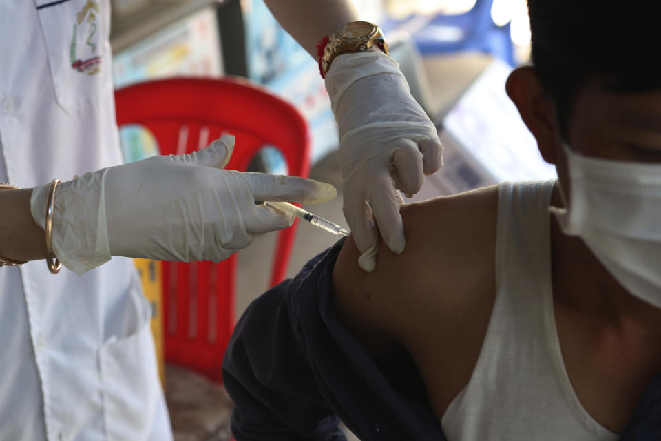 A Cambodian nurse gives a shot of fourth dose of the Pfizer's COVID-19 vaccine at a heath center in Phnom Penh, Cambodia, Friday, Jan. 14, 2022. Cambodia on Friday began a fourth round of vaccinations against the coronavirus, following the recent discovery of cases of the omicron variant, with high-risk groups being the first to receive them. (AP Photo/Heng Sinith)