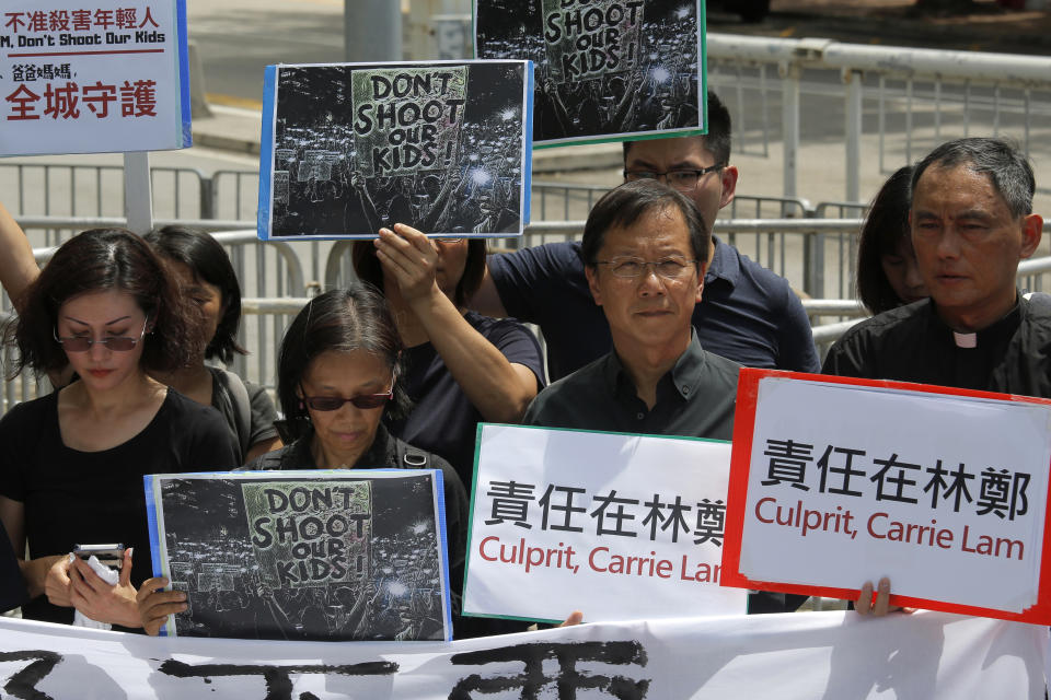 Various of activist groups from parents and religious hold placards outside the government office demanding that stop shooting their kids in Hong Kong, Thursday, June 20, 2019. A Hong Kong student group demanded Wednesday that the city completely scrap a politically charged extradition bill and agree to investigate police tactics against protesters before a Thursday deadline or face further street demonstrations. (AP Photo/Kin Cheung)