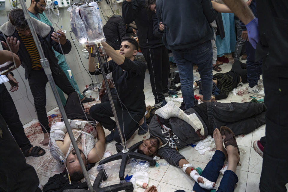 FILE - Palestinians are treated as they lie on the floor after being wounded in an Israeli army bombardment of the Gaza Strip, in the hospital in Khan Younis on Dec. 5, 2023. (AP Photo/Fatima Shbair, File)