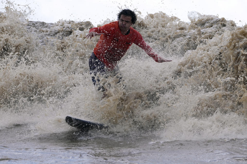 Brazilian surfer Traqua rides the tidal bore wave known as "Pororoca," during the Amazon Surf Festival held in the Canal do Perigoso, or "Dangerous Channel," at the mouth of the Amazon River near Chaves, Marajo Island archipelago, Para state, Brazil, Monday, June 5, 2023. The Pororoca, a word from an Amazonian Indigenous dialect that means "destroyer" or "great blast," happens twice a day when the incoming ocean tide reverses the river flow for a time. (AP Photo/Eraldo Peres)