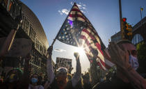 FILE - This photo from Sunday May 31, 2020, shows a man holds a U.S. flag upside down—a sign of distress, as protesters march in Brooklyn, N.Y., during a rally for George Floyd, a black man who died in Minneapolis after being restrained by police officers. (AP Photo/Wong Maye-E, File)