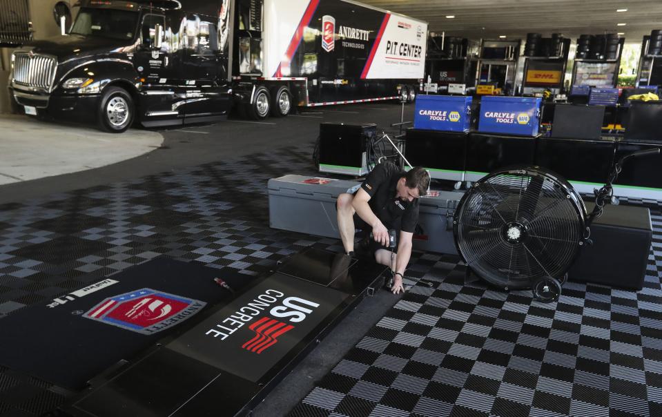 Kirby What, the front end mechanic for driver Marco Andretti, works to pack up the paddock area at the IndyCar Grand Prix of St. Petersburg, Friday, March 13, 2020 in St. Petersburg. NASCAR and IndyCar have postponed their weekend schedules at Atlanta Motor Speedway and St. Petersburg, due to concerns over the COVID-19 pandemic. (Dirk Shadd/Tampa Bay Times via AP)