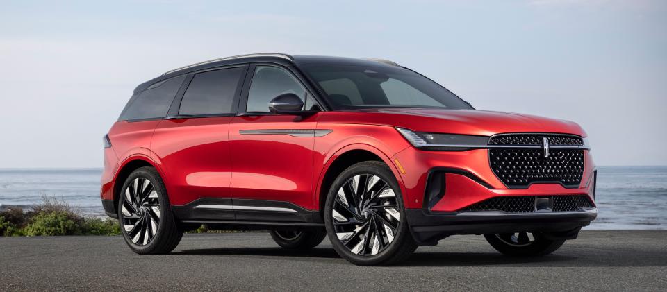 A red 2024 Lincoln Nautilus SUV is parked by the sea.